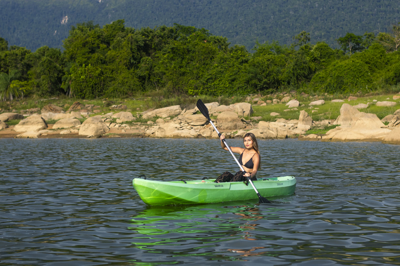 Mujer remando en kayak sobre el Embalse de Topocoro