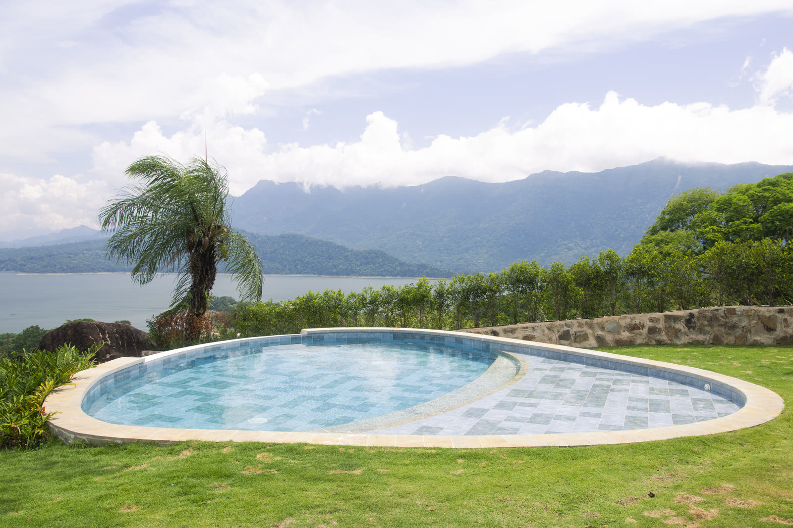 Piscina panorámica con palma y vista al Embalse de Topocoro en Altos de Yariguíes