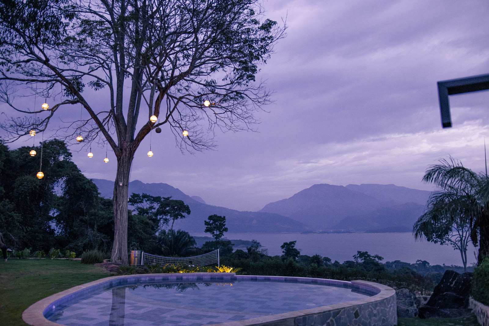 The pool at the Altos de Yariguíes social club lit up at dusk, with a view of the Topocoro Reservoir
