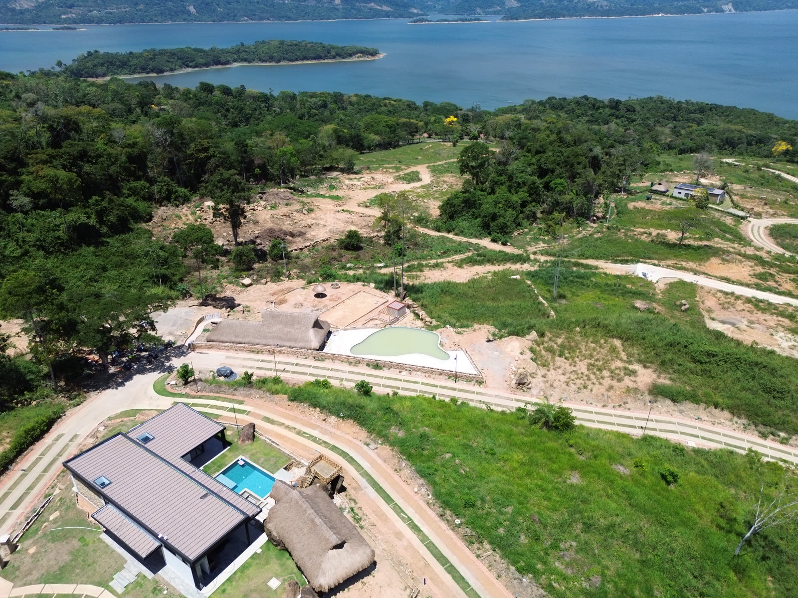 Aerial view of the Altos de Yariguíes model home with its pool, the social club and the Topocoro Reservoir behind